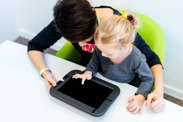 An adult and a child working together on a tablet